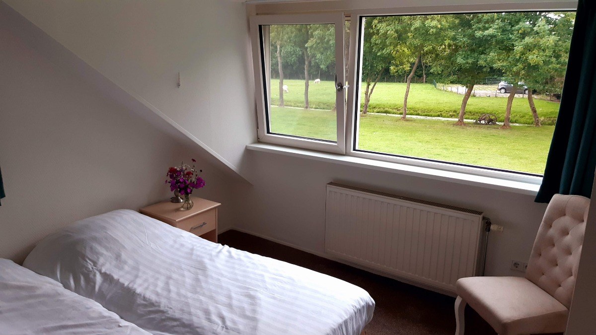 Slaapkamer in Weidezicht met uitzicht op de schapenweide